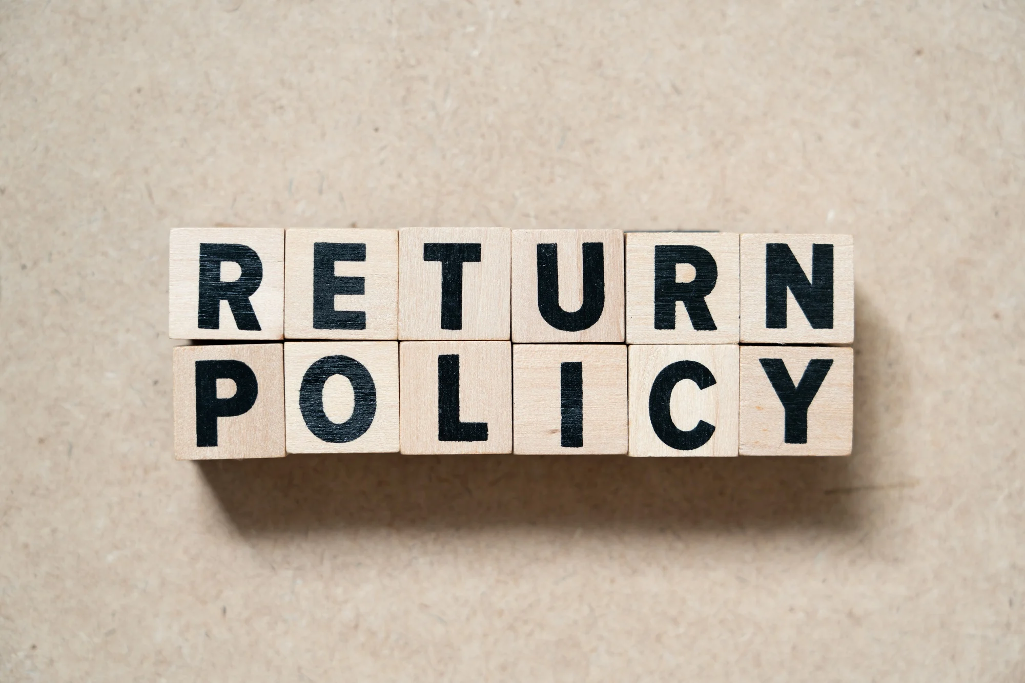 Alphabet letter block in word return policy on wood background