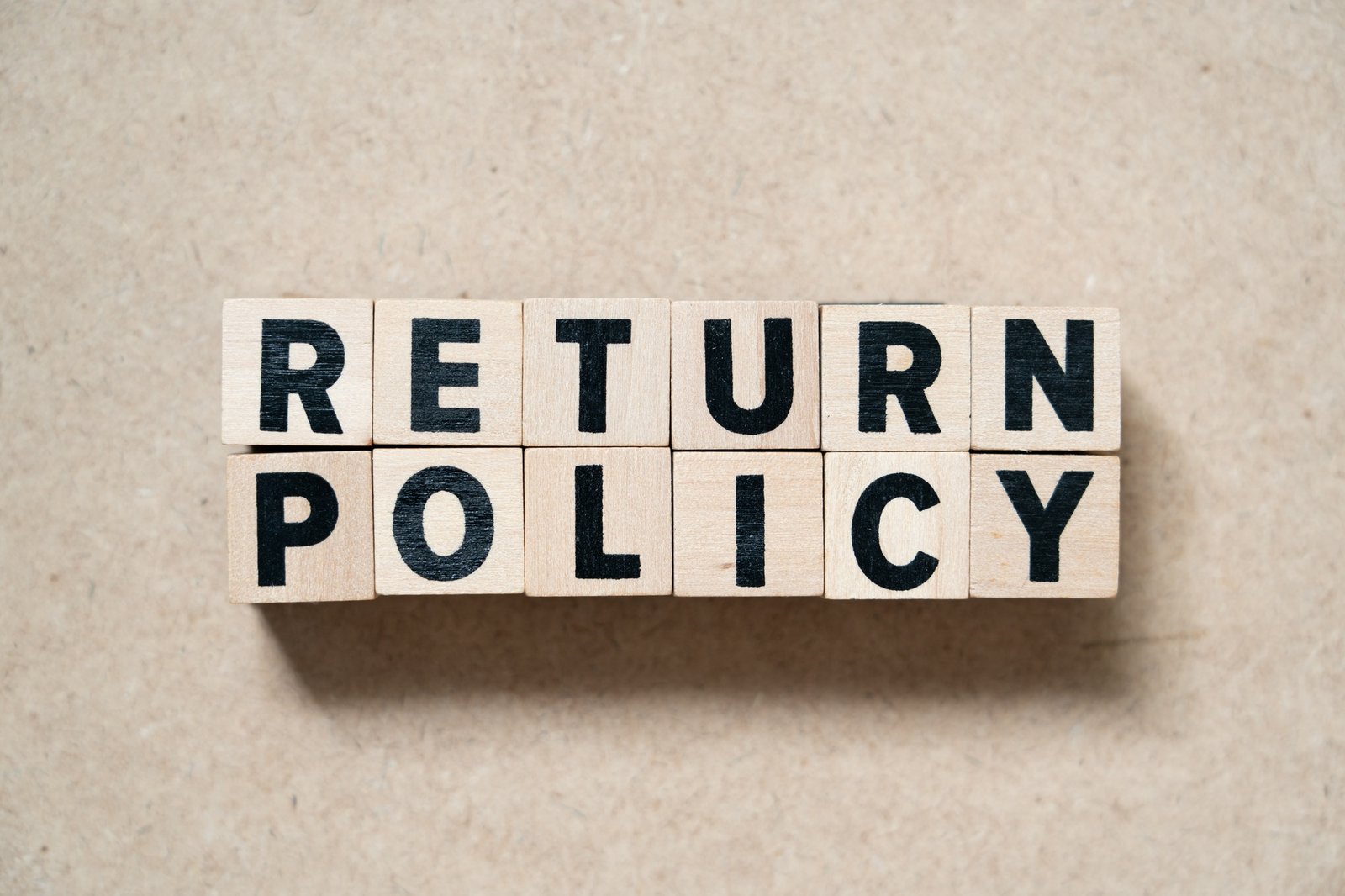Alphabet letter block in word return policy on wood background